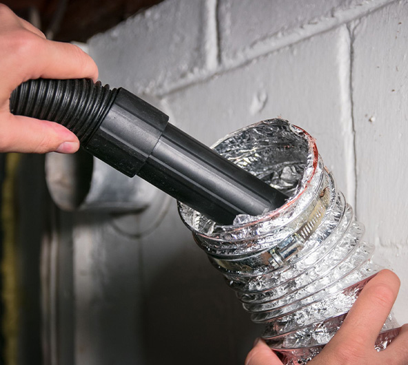 Vacuum hose inserted into dryer vent simulating dryer vent cleaning